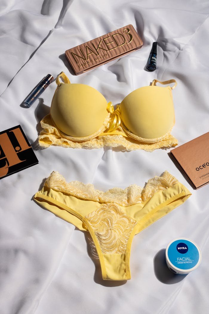Mastering the First Impression: Your intriguing post title goes here Flat lay of yellow lingerie set with beauty products on a white background.